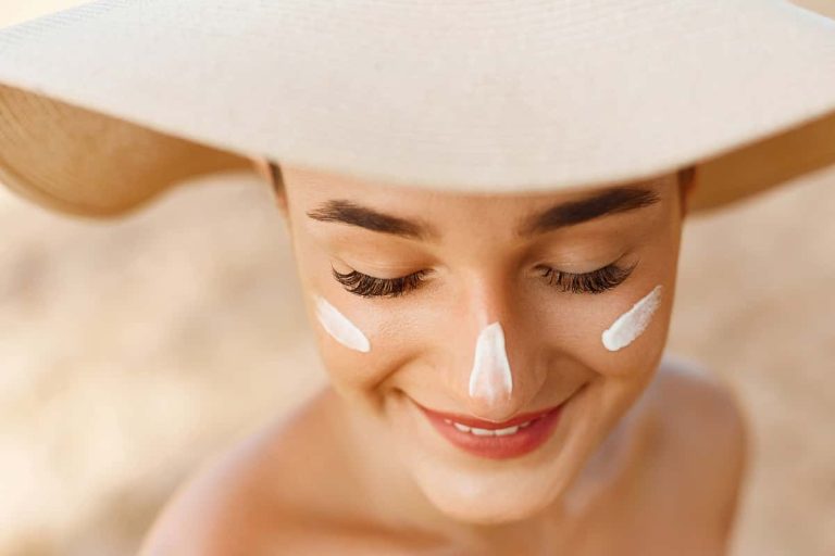Crema hidratante y protector solar aplicado sobre el rostro de una mujer